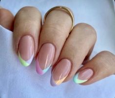 a woman's hand with pink, yellow and green nail polish