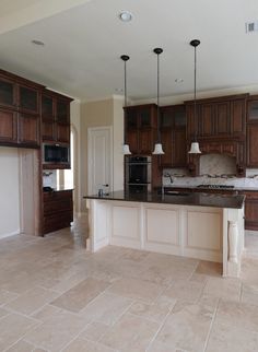 a large kitchen with an island in the middle and lots of cabinets on both sides