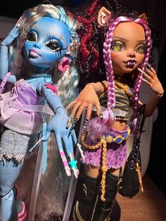 two dolls are posed next to each other