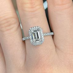 a woman's hand with a diamond ring on top of her finger and an engagement band