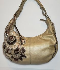 UNIQUE MUTIMEDIA 3D EMBELLISHED LEATHER APPLIQUE RARE CHAMPAGNE BEIGE GOLE MATALIC BRIGHTON FABIOLA PEWTER LEATHER FLORAL APPLIQUE MULTIMEDIA HOBO HANDBAG PURSE Ret $450 I LOVE THE BACK HIDDEN POCKET IN THESE BAGS AND THE ADJUSTABLE STRAP IT HAS A CLIP THAT CAN BE UNDONE AND STRAP UNFOLDS TO USE AS A LONGER SHOULDER BAG.TASSELED HANDSTICHED EMBROIDERED EMBELLISHED EMBOSSED HANDTOOLED LEATHER APPLIQUE EACH BAG TAKES OVER 12 HOURS TO CREATE. BAG IS IN EXCELENT PREOWNED CONDITION, BRIGHTON MASTERPI Leather Applique, Fancy Purses, Embellished Bags, Silver Bags, Hobo Handbag, Embroidered Leather, Leather Floral, Flower Bag, Floral Applique