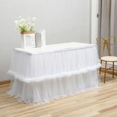 a table with a white tulle skirt on it