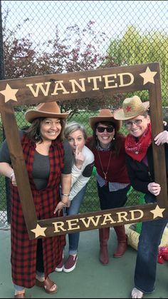 four women pose for a photo in front of a sign that says, wanted reward