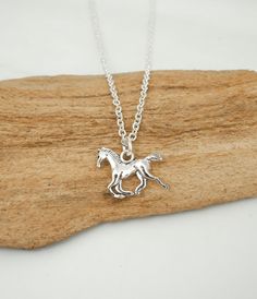 This antique silver horse necklace makes a great gift for young equestrians. This necklace includes: - reversible horse pendant (size 15 mm | 5/8 inch) - silver anchor chain (14 to 36 inches) To Add Initial or Number Charms: https://etsy.me/3RnJ5qD  To Add Birthstone Charms: https://etsy.me/3Zif2Uw We ship twice a week, usually Mondays and Thursdays. To USA: - Provider: Chit Chats Express (who deals directly with USPS) - Arrival Time: 5-10 days (1-3 days for preparation, 5-7 for shipping time) - Tracking: Yes - Ships out from Vancouver, Canada To Canada: (Please note, we have increased our shipping cost to include GST since Etsy no longer allows us to charge this separately.) - Provider: Canada Post - Arrival Time: 10-14 days on average - Tracking: No - Ships out from Vancouver, Canada To Horse Pendant, Horse Necklace, Anchor Chain, Silver Horse, Horse Jewelry, Chit Chat, Horses Pendant, Horse Gifts, Necklace Antique