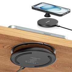 an iphone charging on top of a wooden table