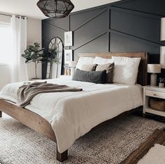 a bedroom with black walls and white bedding