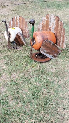 an old rusted metal pipe and two rusty shovels sitting on top of a hole in the ground