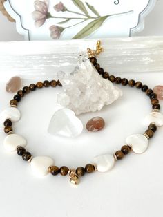 Necklace Length : 18 inches + 1.5 inches extender This stunning necklace is made with natural AAA 8 mm Tiger's Eye beads and beautiful heart shape shell beads. This beautiful necklace is going to be nice gift for your loved ones. Tiger eye  enhancing intuition, courage, and self-confidence. The stone is also believed to offer protection, particularly during travel and against negative energies or intentions. Tiger's Eye is the earthly stone to use when you feel more grounded. It can help provide Tiger Eye Necklace, Shell Beads Necklace, Necklace Shell, Tiger Eye Gemstone, Tigers Eye Necklace, Solar Plexus Chakra, Tiger Eye Beads, Necklace Heart, Sacral Chakra