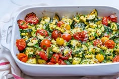 a casserole dish with tomatoes, zucchini and other veggies