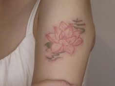 a woman's arm with a pink flower tattoo on it