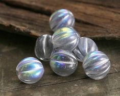 some shiny glass beads are laying on a wooden surface