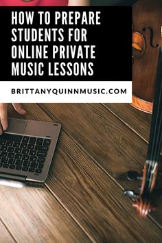 a person using a laptop computer on top of a wooden table with violin in the background