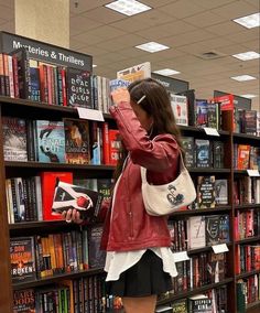 a woman standing in front of a bookshelf with her hand on her head