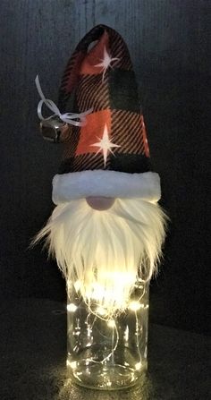 a glass jar with a light up santa hat on it