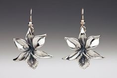 Marty Magic Store - Orchid Earrings, $95.00 (http://www.martymagic.com/products/Orchid-Earrings.html) Orchid Pendant, Travel Charm Bracelet, Orchid Necklace, Magic Jewelry, Orchid Jewelry, Sterling Silver Flower Earrings, Dragon Logo, Magic Dragon, Orchid Earrings