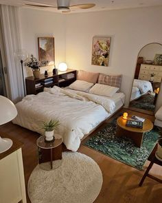 a bed sitting in the middle of a living room next to a dresser and mirror