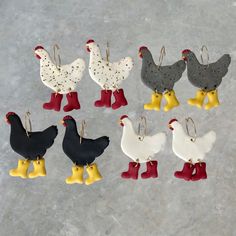 six chicken ornament hanging from hooks on concrete