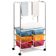 three bins with towels on top and four plastic containers under the towel rack for storage