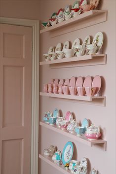 the shelves are filled with teacups and plates on them, along with other dishes