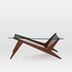 a glass and wood coffee table with an unusual design on it's top,