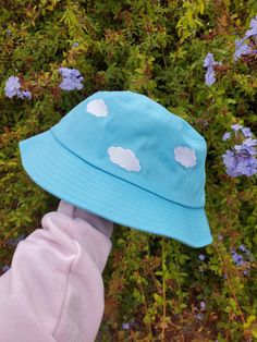 "Do you love to have your head in the clouds? This cloudy sky bucket hat is a Magical Girl Bella original art and design, featuring embroidery of 5 clouds around the blue bucket hat. Bucket Hat Inside circumference: approximately 23\" - the standard adult hat size This listing has limited quantity that are ready to ship. **MORE DESIGNS AVAILABLE ON MY WEBSITE MAGICALGIRLBELLA.SQUARE.SITE" Rainbow Bucket Hat, Bucket Hat Aesthetic, Rave Ideas, Blue Bucket Hat, Hat Aesthetic, Head In The Clouds, Cloudy Sky, Magnolia Pearl, In The Clouds