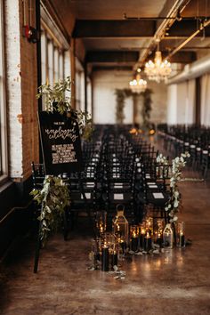 rows of chairs are lined up with candles and greenery on the tables in front of them