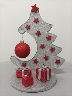 a silver christmas tree with red presents under it