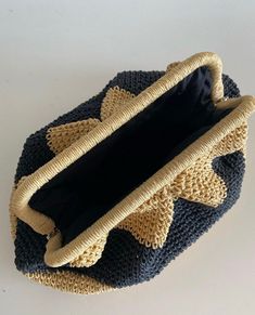 a crocheted basket with handles and roped edges sits on a white surface