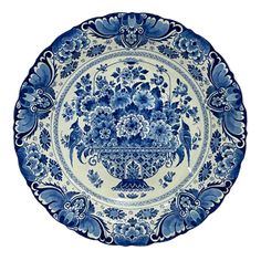 an ornate blue and white plate with flowers on the bottom, in front of a white background