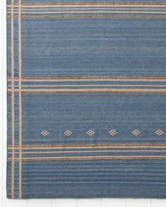 a blue and beige rug with stripes on it