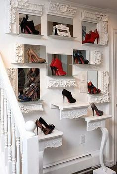 there are many pairs of high heel shoes on the shelves in front of the stairs