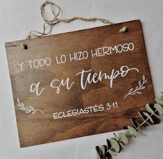 a wooden sign hanging from the side of a wall with writing on it that says, y todo lo hizo hermoso as su tempo