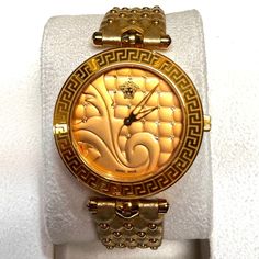 Gold Tone Versace Ladies Watch On A Leather Gold Tone Strap With Studded Embellishments And A Hidden Deployment Gold Buckle Clasp. An Extra Unworn Gold Versace Strap Is Included. Original Box & Papers Are Included. Luxury Gold Diamond Watch For Evening, Luxury Jubilee Bracelet Jewelry For Evening, Designer Gold Diamond Watch For Formal Occasions, Designer Yellow Gold Diamond Watch Gift, Designer Gold Diamond Watch, Designer Yellow Gold Diamond Watch As Gift, Designer Yellow Gold Diamond Watch, Luxury Gold Diamond Watch With Jubilee Bracelet, Designer Gold Watch For Anniversary