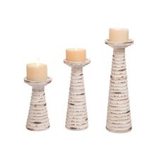 three white candles sitting next to each other