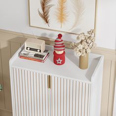 a white cabinet with a red knitted star on it and a radio next to it