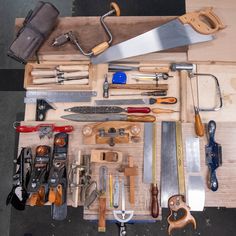 many different tools are laid out on a workbench, including knives and pliers