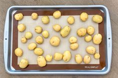 peeled potatoes on a baking sheet ready to be baked in the oven for roasting