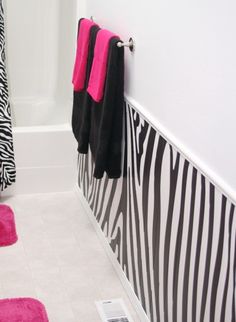 a bathroom with pink and black towels on the wall