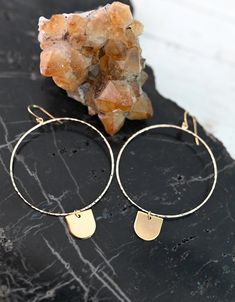 "These 14k gold fill geometric hoops are every girl's dream. As light as a feather, you can wear these from day into the evening. They're classic, chic, and effortless. The half-circle dangle charm is the cutest little addition to the hoop that makes it unique and full of magic. ▲ 14k gold fill 2\" hoops ▲ 24k gold plated brass charm ▲ Drop length: 3\" ▲ Weight: 1/8 oz ▲ Hypoallergenic ▲ Gift-ready in a beautiful white jewelry box ▲ Handmade just for you SHOP FIERCE FORWARD JEWELRY: https://www. Gold Minimalist Earrings, Hoop Earrings With Charm, Earrings Handmade Boho, Jewelry Hippie, Handmade Boho Jewelry, Minimalist Earrings Gold, White Jewelry Box, Box Handmade, Brass Charms