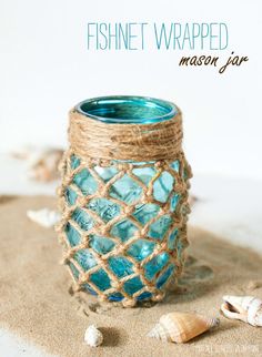 a blue glass vase sitting on top of a burlocked table cloth covered jar