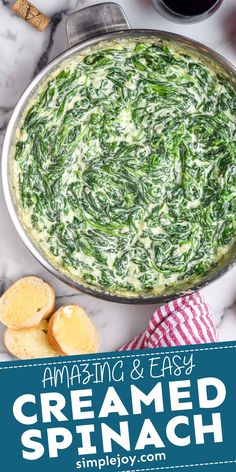 a spinach and cheese dip in a pan with crackers next to it on a marble countertop