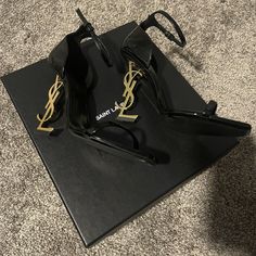 Yves Saint Laurent Black Opyum 110 Sandals Ankle Strap In Patent Leather With Gold-Tone. Preowned Signs Of Wear 2-3 Times Only. Condition Like New. Excellent Condition. Comes With Original Box W/ Dust Bag + Small Envelope. Size: 38.5 (Us Size: 8.5) Made In Italy Authentic 100% Retail $1,290 Purchased At Ysl Store. (Proof Of Purchase If Needed) Free Shipping + Final Sale!! + No Returns!!! Sandals With A Structured Heel Decorated With Metal Ysl Initials And Featuring An Adjustable Ankle Strap. 100 Ysl Store, Shoes Ysl, Small Envelope, Shoes Heels Classy, Ysl Heels, Yves Saint Laurent Shoes, Paint Wall, Vintage Ysl, Dream Outfits