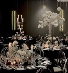 a dining room filled with lots of tables covered in white flowers and centerpieces