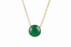 Featured here is a stunning, round emerald pendant in fine 14k yellow gold. Displayed in the center is a medium-green emerald accented by a simple bezel gold mount. The earth mined, green emerald has a desirable lush green color. This emerald is 100% earth mined and is not perfect! Gorgeous flaws are seen within the stone, embrace uniqueness! The chain is attached to this piece, non-removal. Total Carat Weight: 0.90cts Setting Style: Bezel Setting Material: 14K Yellow Gold Main Stone: Emerald Sh Elegant Gold Emerald Necklace, Elegant Emerald Round Pendant Necklace, Elegant Emerald Necklace With Round Pendant, Elegant Emerald Birthstone Necklace With Round Pendant, Elegant Emerald Pendant Necklace With Bezel Setting, Green Round Fine Jewelry Necklaces, Fine Jewelry Green Round Necklaces, Formal Round Emerald Necklaces, Green Gemstone Round Cut Necklace