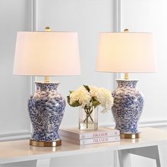 two blue and white vases sitting on top of a table