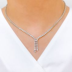 Elevate your style with this Graceful Diamond Tassel Necklace Set. Crafted with 18k white gold and 2.94ct diamonds in round shape, this set has a set length of 17" and a drop length of 1". It features a push lock with clasp and comes with matching earrings. The necklace has a weight of 30.8g, making it a perfect addition to your high fashion wardrobe. PRODUCT DETAILS Gold Purity(karat): 18k Item Weight(grams): 30.8 Item Finish: White Gold Stone: Diamond Diamond Weight(carats): 2.94ct Diamond Col White Gold Diamond Tennis Necklace For Evening, Evening White Gold Diamond Tennis Necklace, Formal Platinum Bridal Necklace With Diamond Accents, Exquisite Diamond Drop Necklace For Formal Occasions, Exquisite Drop Diamond Necklace For Formal Occasions, Formal Bridal Necklace In White Gold-colored Platinum, White Gold Diamond Bridal Necklace For Evening, Formal Bridal Necklace In Platinum White Gold, Evening Bridal Necklace In White Gold With Diamonds