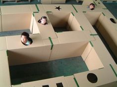 three people are in cardboard boxes with holes cut out to make them look like they're playing