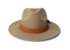 The Rito Hat from the Oaxaca Collection Type: Center Dent Wide Brim FedoraSpecifications: Adjustable Size- With a tie of a knot, adjust the fit of your hat to the ideal size from 21 ¼ to 23 ¼ inches.Dimensions: Wired Brim: 2 7/8", Crown: 4"Color: CamelMaterials: 65% Cotton , 35% Polyester Vegan leather hat bandTurkey featherOrigin: All of our hats begin in Ecuador as the body is molded, then completed in Tucson, AZ where they are shaped, trimmed and designed with artisanal hatbands, leather good Elegant Adjustable Flat Bill Hat, Elegant Adjustable Sun Hat With Flat Bill, Elegant Adjustable Flat Bill Sun Hat, Adjustable Curved Brim Panama Hat For Fall, Adjustable Panama Hat With Curved Brim For Fall, Fall Panama Hat With Adjustable Curved Brim, Adjustable Wide Brim Panama Hat For Winter, Winter Adjustable Fedora Panama Hat, Winter Adjustable Wide Brim Panama Hat