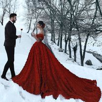 a man and woman dressed in formal wear walking through the snow