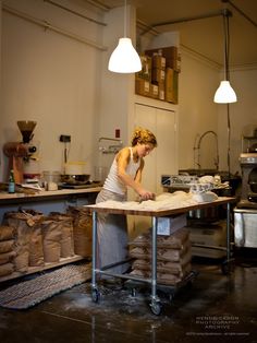 a woman working in a kitchen with lots of bags